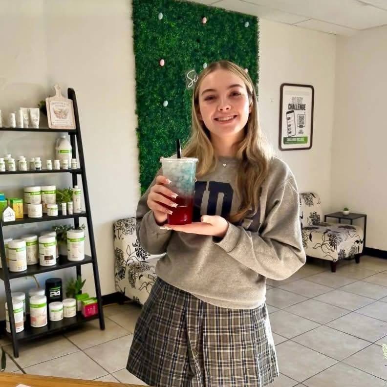 A guest showing off a layered blue and red mega tea inside the club
